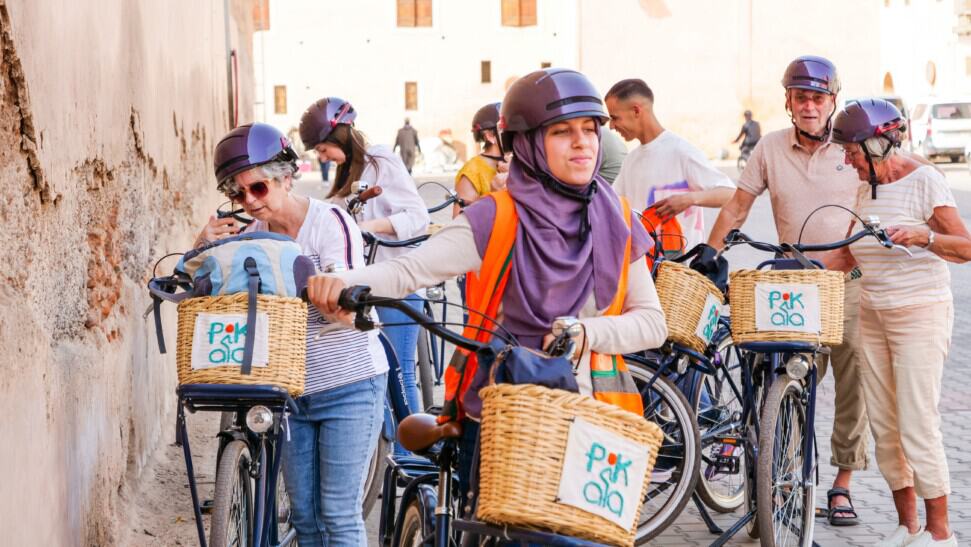 A group of cyclists walk their bikes along the Medina wall in Marrakech