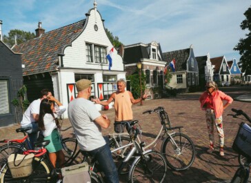 A guide stops in a traditional Dutch town to explain the surroundings