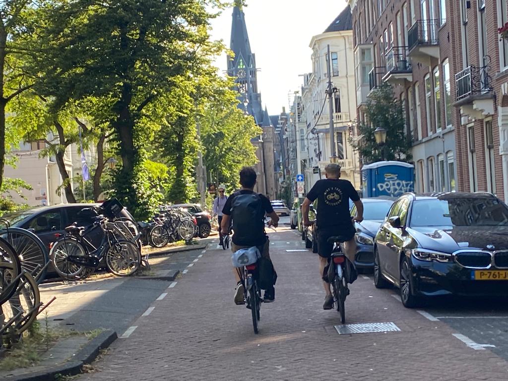 Two cyclists make their way through Amsterdam