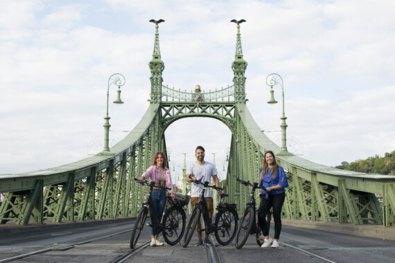 People with bikes on a green bridge