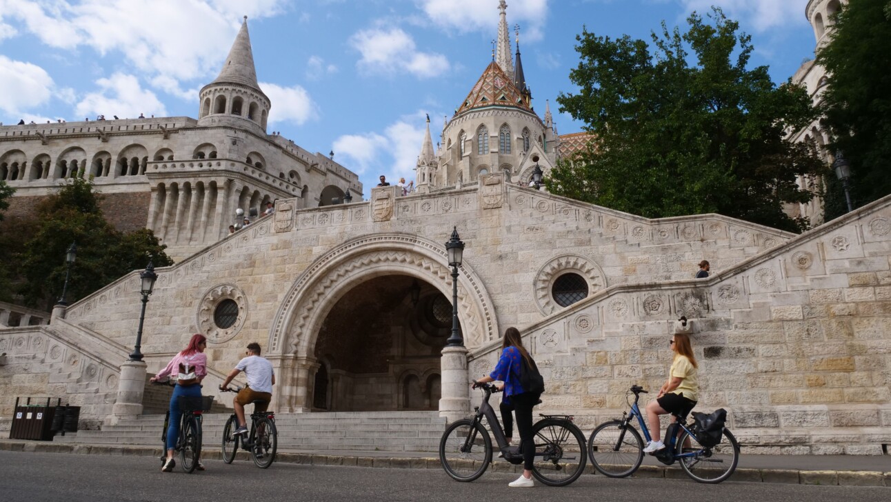 A group of four cyclists approach the Budapest Castle