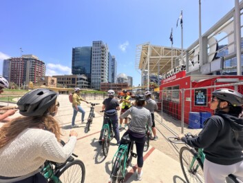 A group of cyclists stop outside Petco Park in San Diego