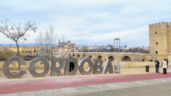A woman poses for a photo with the Córdoba city sign