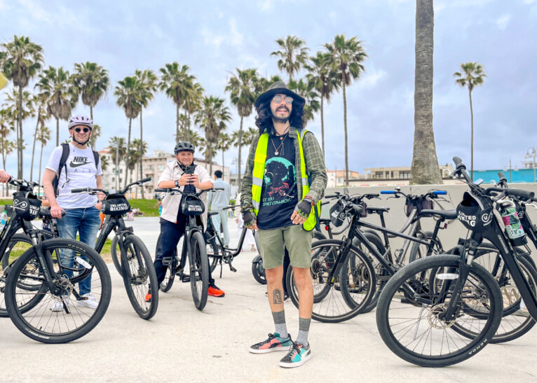 A group of people bike along the Santa Monica Pier